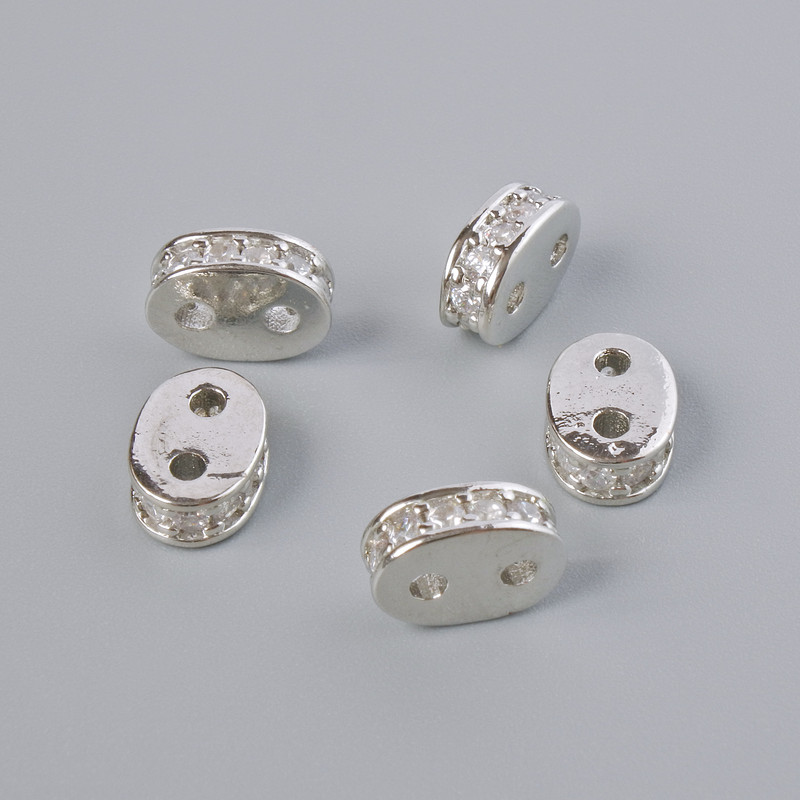 Rozdělovací korálek na dvě nitě se bílými krystaly, stříbrný odstín kovu, průměr 8×3 mm