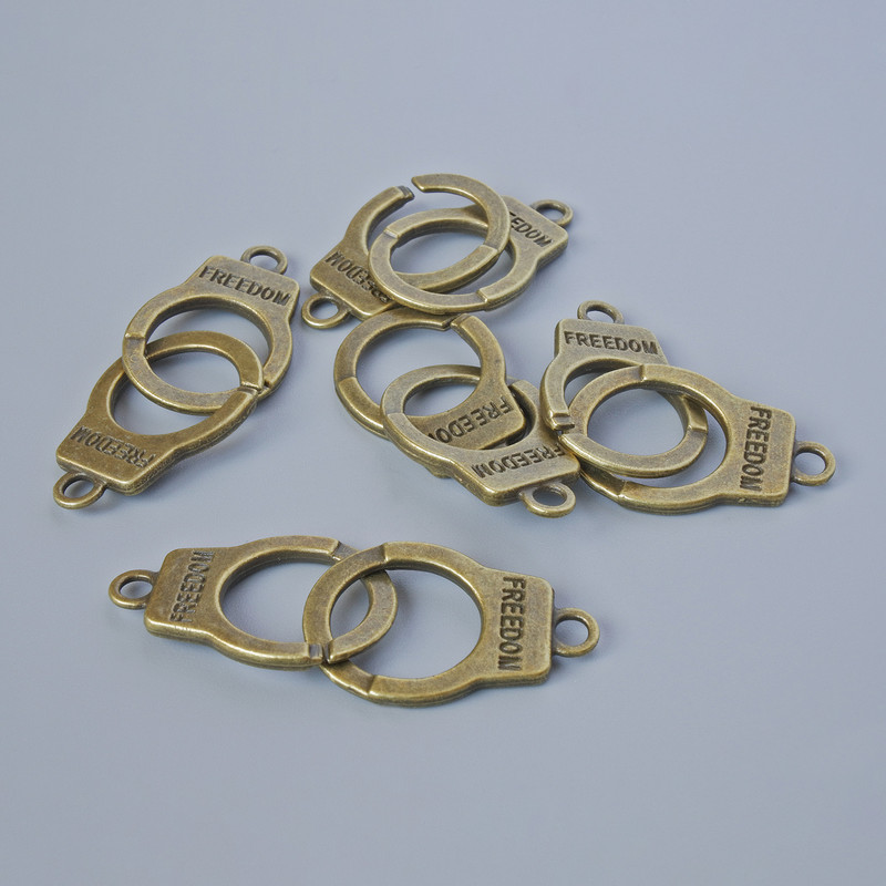 Přívěšek «Pouta», rozměr 23×14 mm, tloušťka 5 mm, průměr otvoru 2,4 mm, délka 40 mm, balení 5 ks ±, bronzová barva kovu