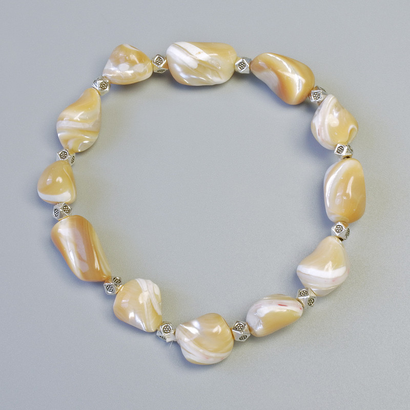 Náramek z béžové perleti, fazetované korálky, průměr 10×13 mm ± (elastický), délka 18 cm ±, s kovovými vsadkami