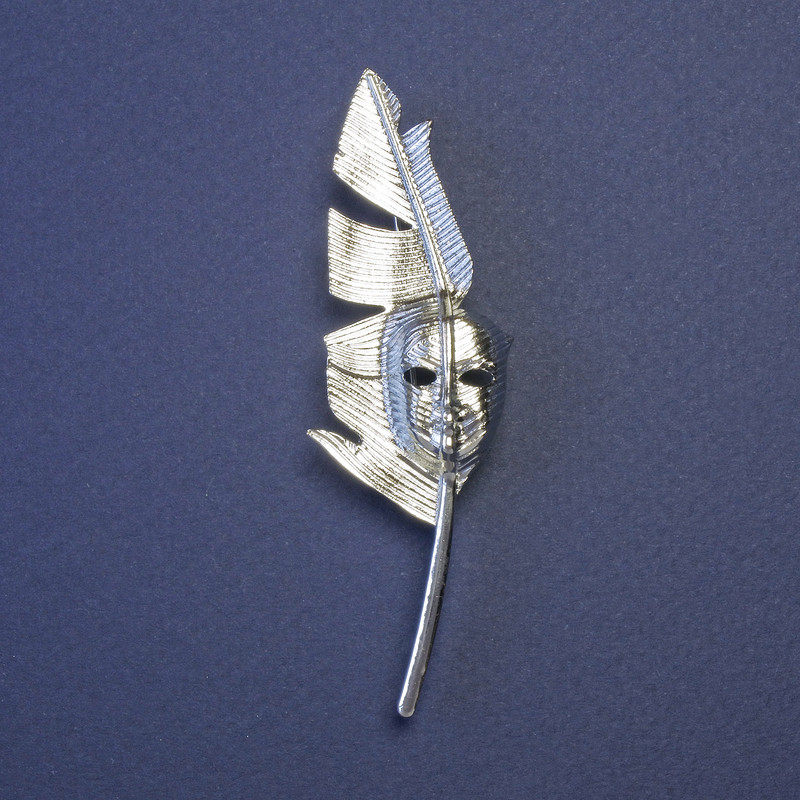 Brož či přívěsek «Pero spisovatele s maskou», stříbrný kov, 80×23 mm