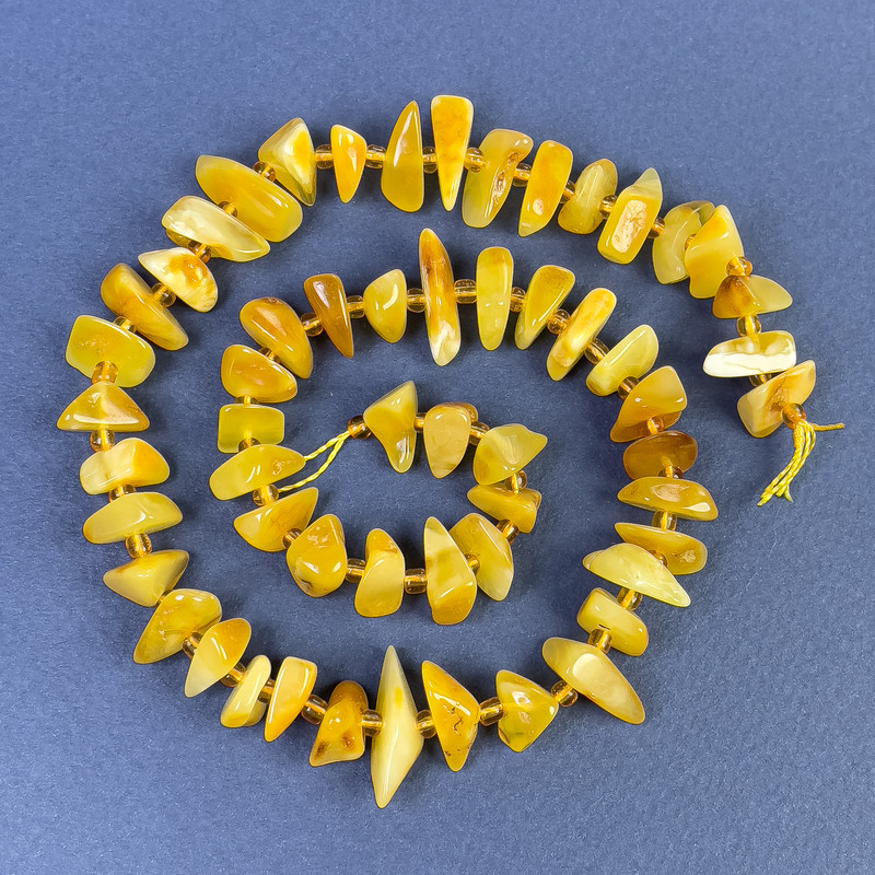Jantarové korálky drobné 9–12×3–5 mm ± s rokajlem 2,5 mm ± na niti, délka 39 cm