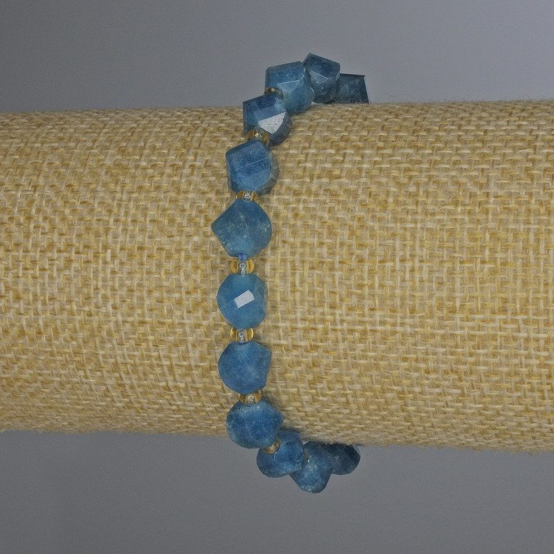 Náramek z broušeného apatitu ve tvaru rombu, rozměr 8×7 mm ±, se skleněnými korálky o průměru 3 mm ±, délka 18 cm ±, na elastické bázi