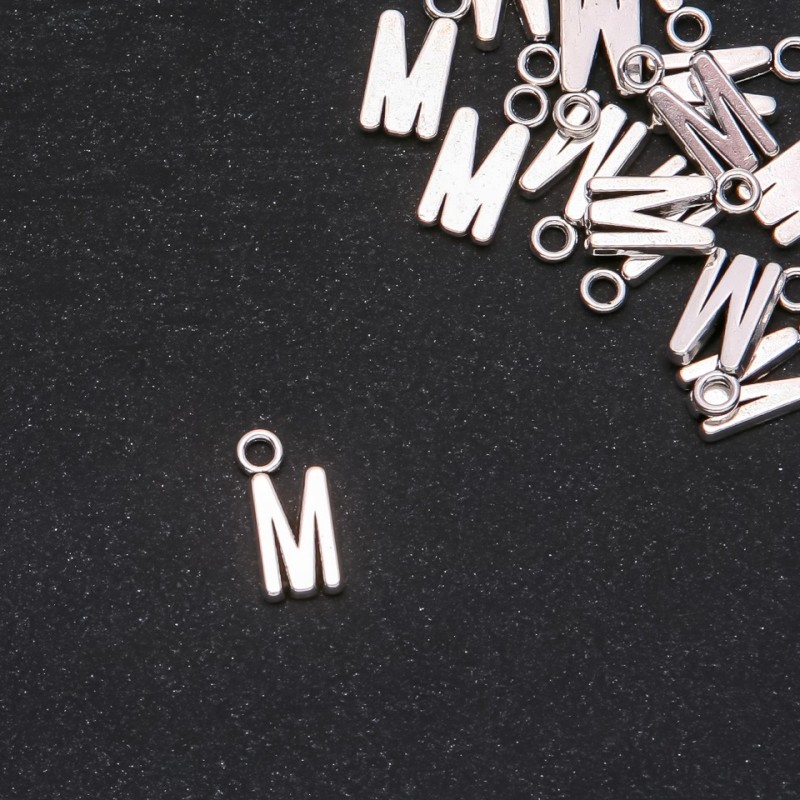 Přívěšek s písmenem M, 17×7 mm, balení 20 g (± 15 ks)