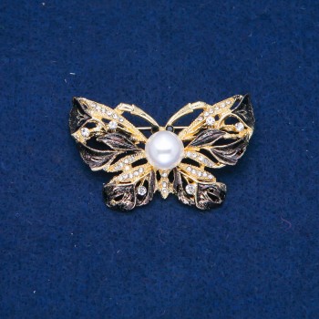 Brož Motýlek zlatistého kovu, černý smalt, bílé štrasové kamínky a perlová korálka 46×30 mm +