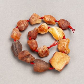 Karneolové korálky nezpracované, navlečené na niti, průměr 16–30×15–25 mm (±), délka 42 cm+