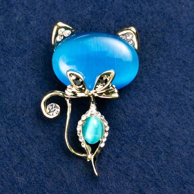 Brož Kočičí oko modré barvy s bílými štrasovými kamínky, 45×28 mm, žlutý kov