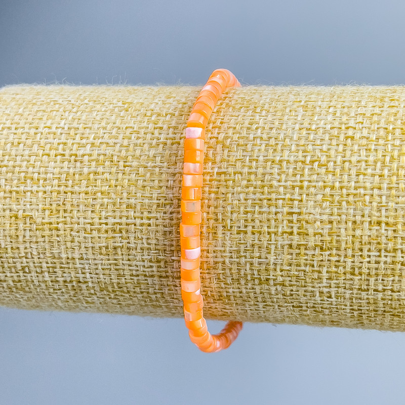 Náramek z tónované oranžové perleti, diskové korálky, průměr cca 4×2 mm, délka 18 cm (na elastické šňůrce)