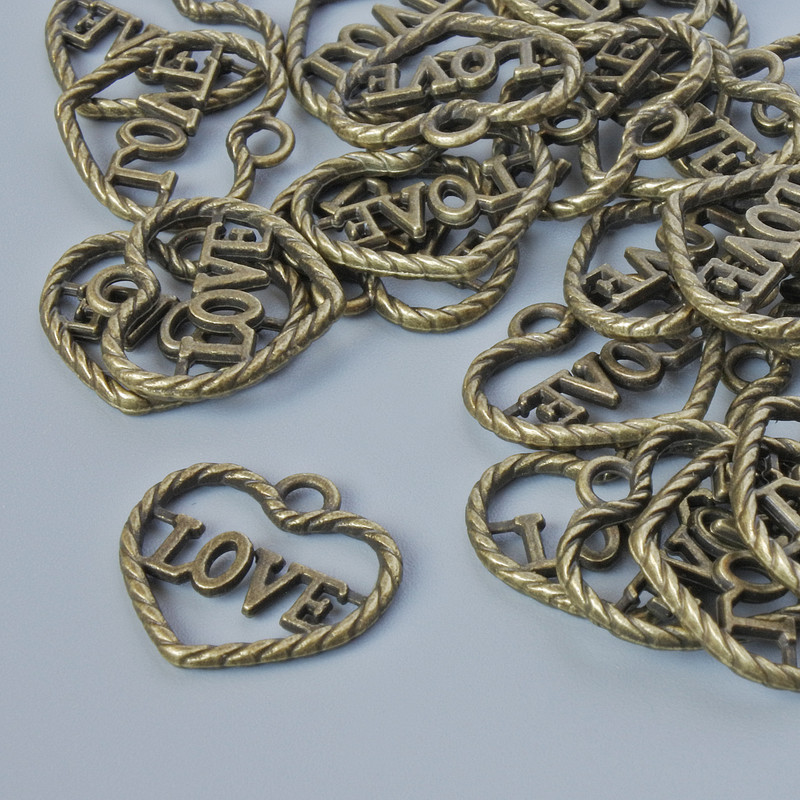 Přívěšek závěsný ve tvaru srdce, rozměry cca 13,5 × 14,5 mm, průměr otvoru 1,9 mm, balení 28 ks ±, bronzová barva kovu