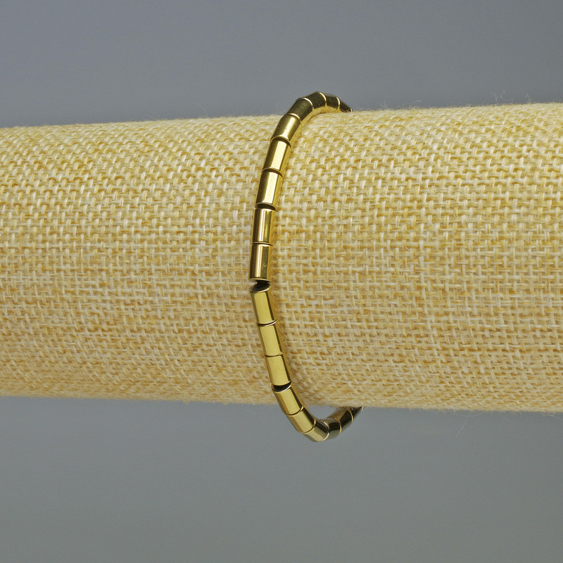 Náramek z hematitu cylindrického tvaru, zlatá barva, průměr 6×4 mm, délka 18 cm, pružný