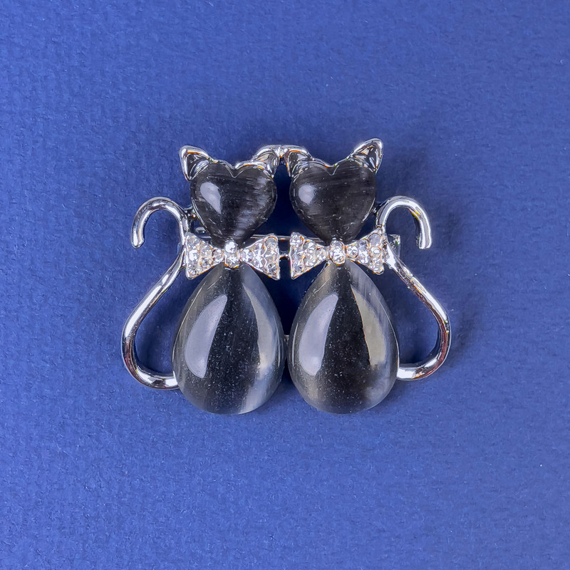 Brož Kočky s tmavě šedým kočičím okem, bílé štrasové kamínky, stříbrný kov, rozměr 31×38 mm +