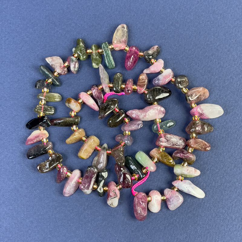 Korálky z turmalínu, tvar 6–14×4 mm ±, s rokajly na niti, délka 39 cm