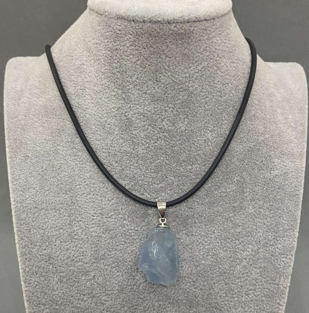 Přívěšek z neopracovaného akvamarínu, průměr různých velikostí 31×16–37×18 mm ± na šňůrce, průměr 2,5 mm ±, délka 50 cm ± 5 cm, řetízek