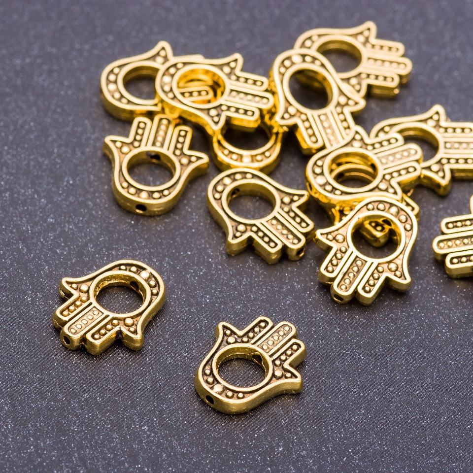 Korálková vložka ve tvaru dlaně, barva staré zlato, rozměry 14×12×2,5 mm, otvor 5 mm, balení 20 g ± 19 ks