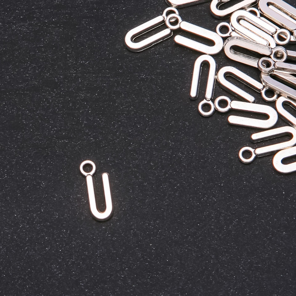 Přívěšek s písmenem U, 17×7 mm, balení 20 g (± 30 ks)