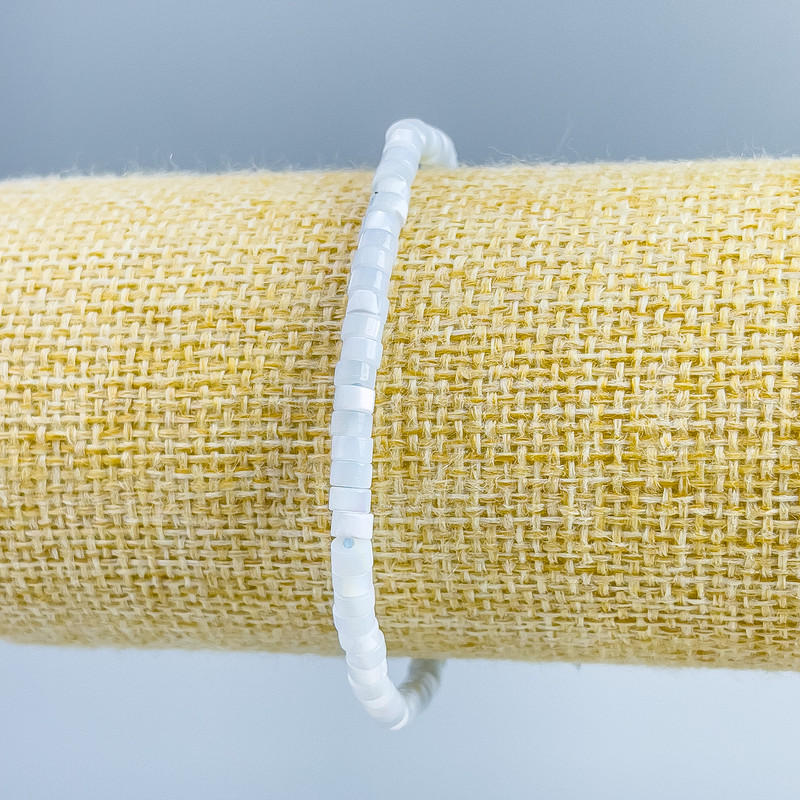 Náramek z tónované perleti světle modré barvy, diskové korálky o průměru 4×2 mm, délka 18 cm (elastický)